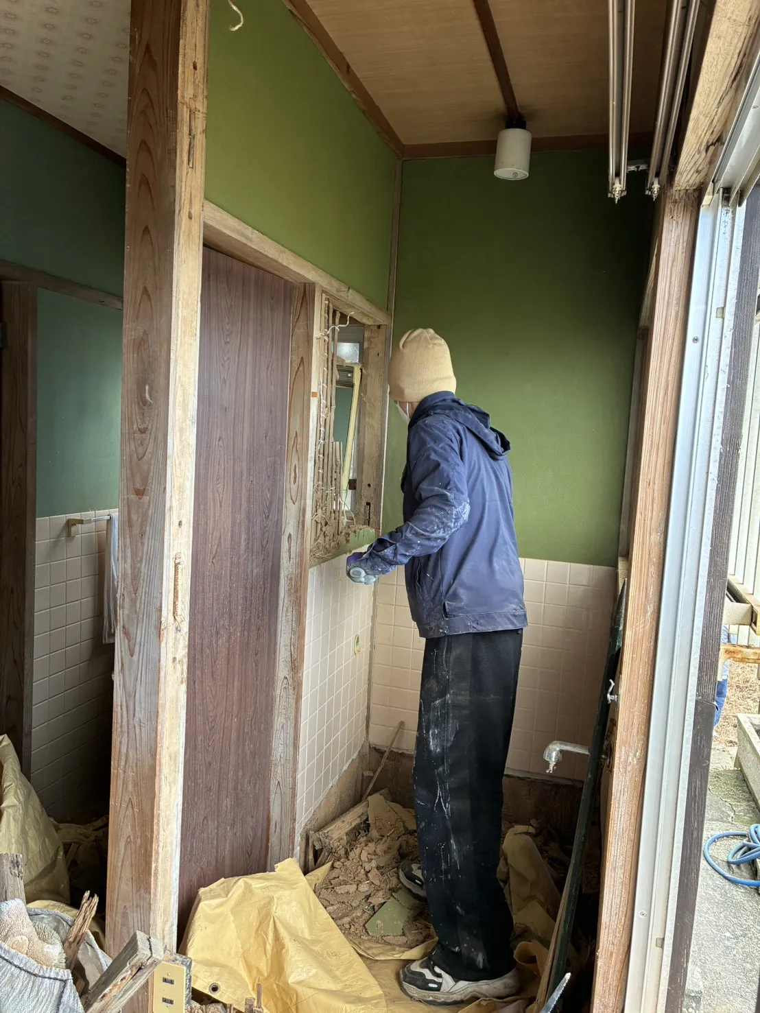 壁の解体作業中。粉塵まみれで奮闘