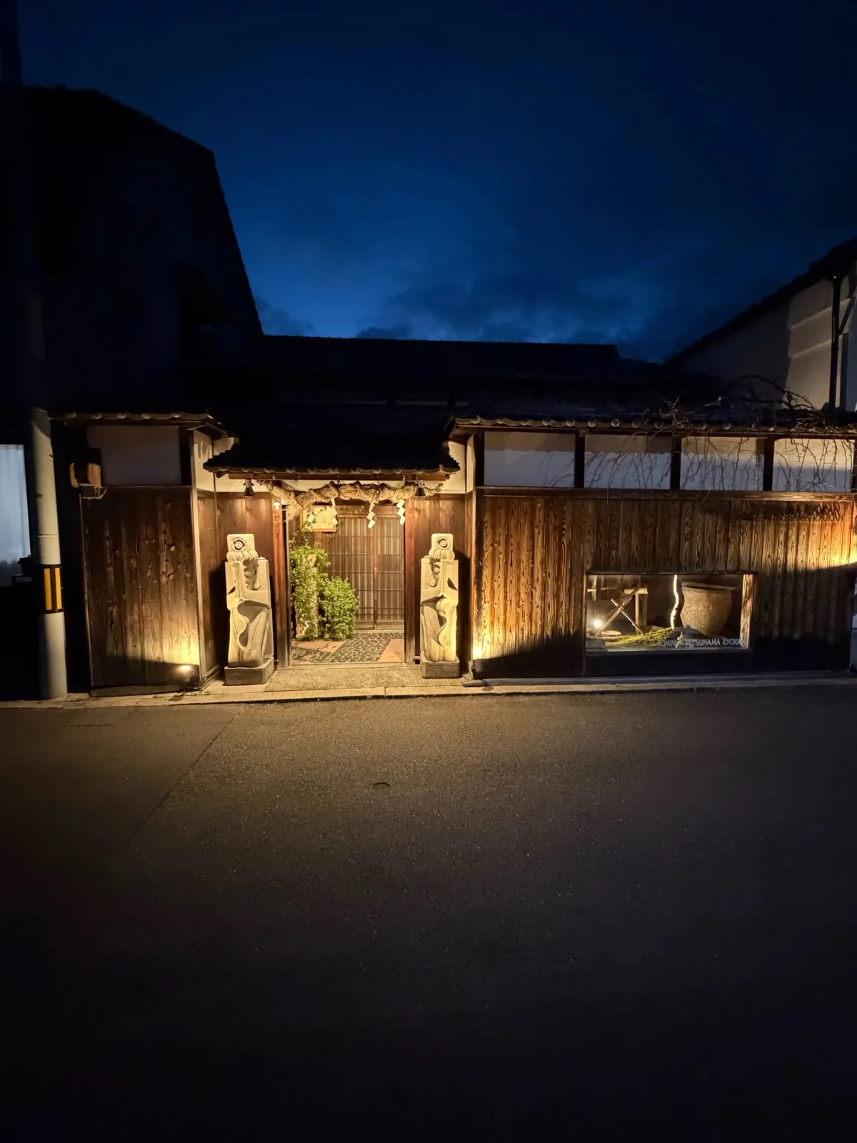 三津浜旅館の外観。木造の趣ある佇まいが夜に映える